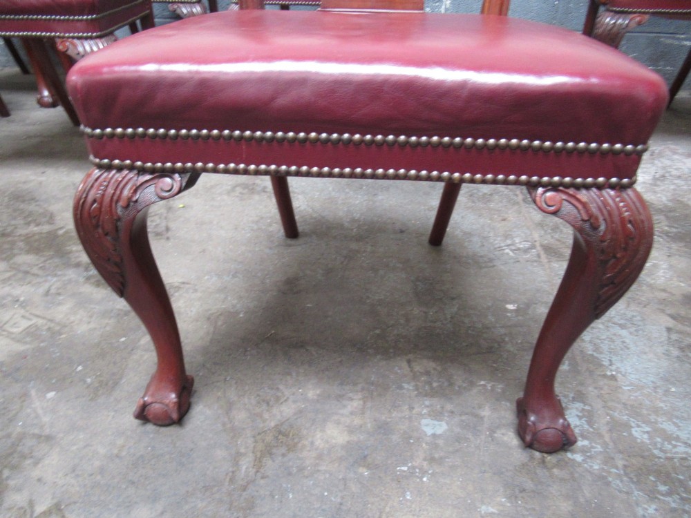 A set of eight mahogany Chippendale style dining chairs featuring carved pierced splats, red leather seats with brass studding, and cabriole legs with ball and claw feet. View VII