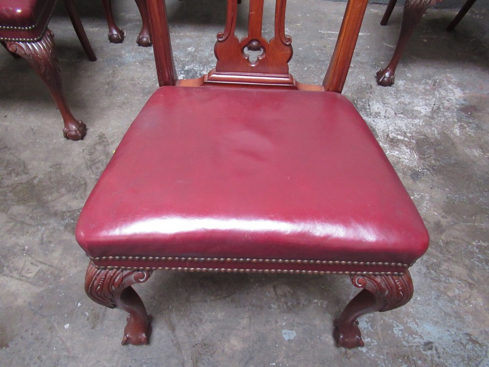 A set of eight mahogany Chippendale style dining chairs featuring carved pierced splats, red leather seats with brass studding, and cabriole legs with ball and claw feet. View VIII
