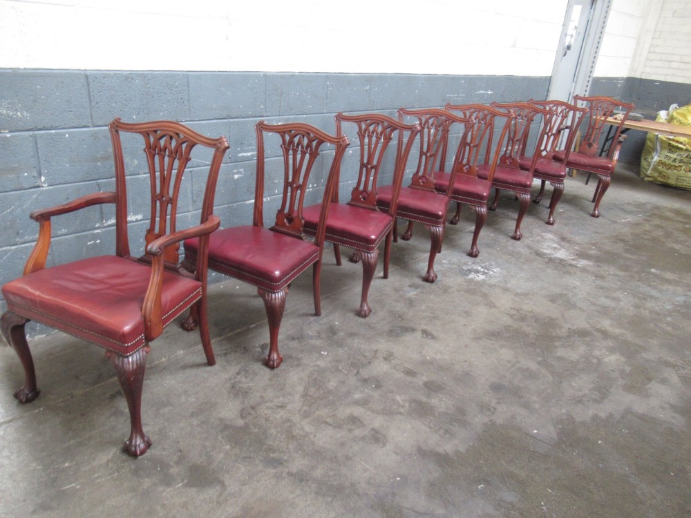 A set of eight mahogany Chippendale style dining chairs featuring carved pierced splats, red leather seats with brass studding, and cabriole legs with ball and claw feet. View IX