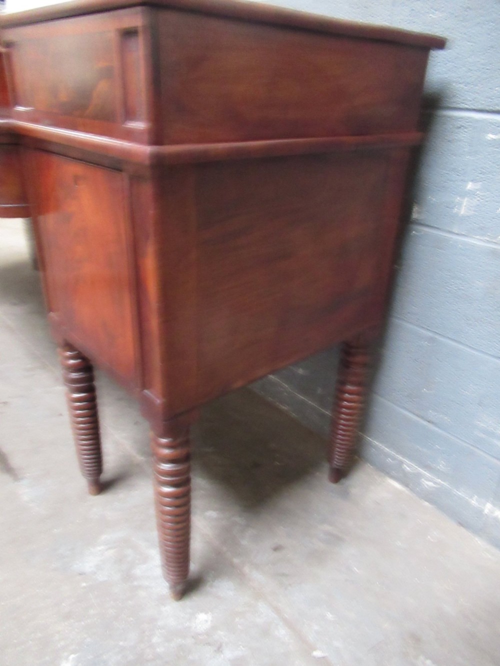 An early 19th century Scottish mahogany sideboard featuring a raised stage back, pedestal cupboards, central drawers, and spiral turned legs. View III