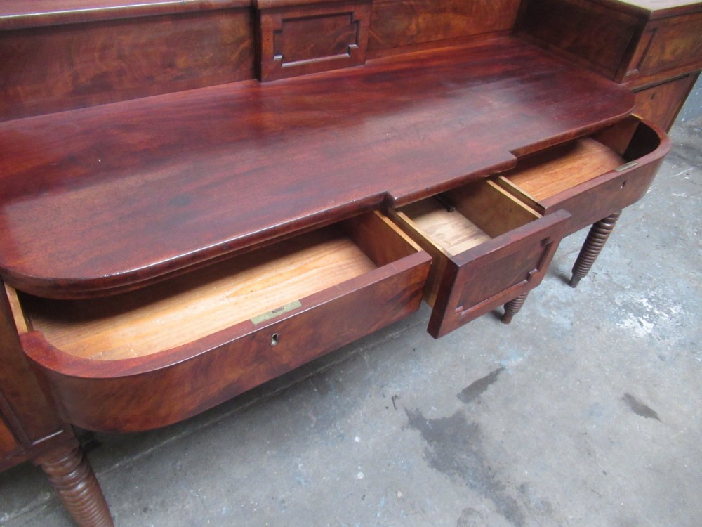 An early 19th century Scottish mahogany sideboard featuring a raised stage back, pedestal cupboards, central drawers, and spiral turned legs. View IX