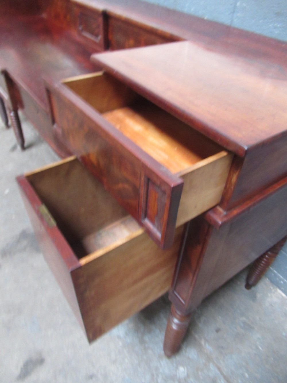 An early 19th century Scottish mahogany sideboard featuring a raised stage back, pedestal cupboards, central drawers, and spiral turned legs. View XII