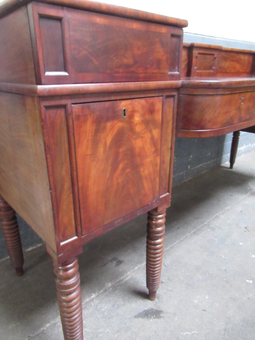 An early 19th century Scottish mahogany sideboard featuring a raised stage back, pedestal cupboards, central drawers, and spiral turned legs. View XIV