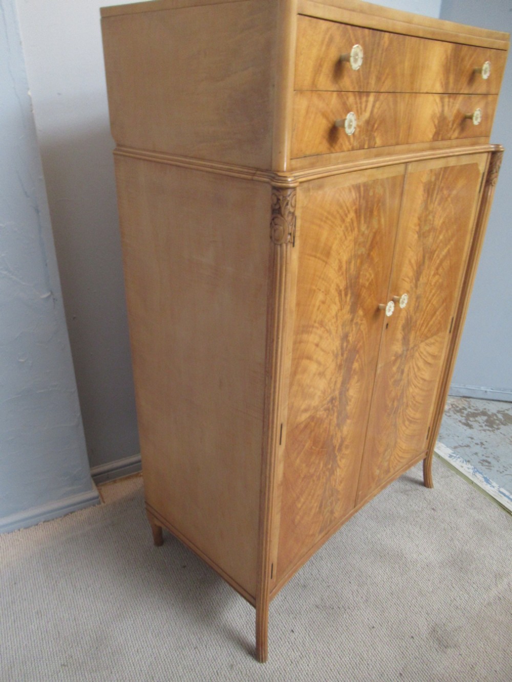 A mid-century fitted tallboy cabinet in pale mahogany and maple featuring two top drawers above double doors opening to reveal internal sliding shirt trays. View III