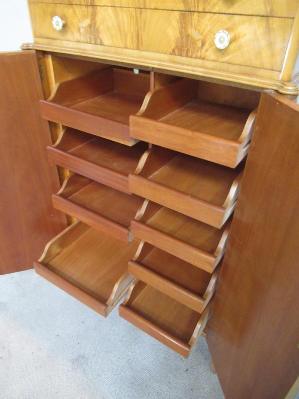 A mid-century fitted tallboy cabinet in pale mahogany and maple featuring two top drawers above double doors opening to reveal internal sliding shirt trays. View VII