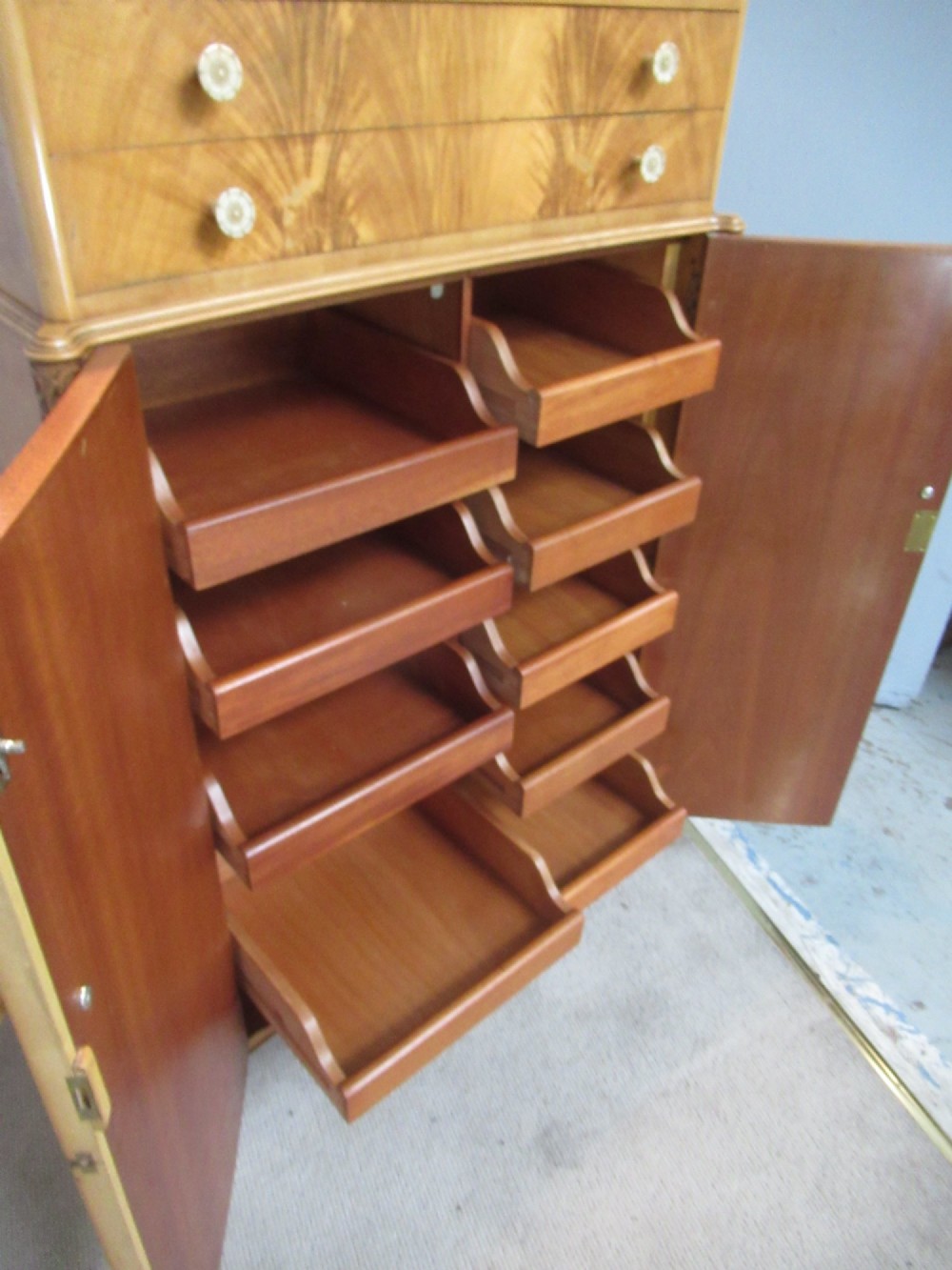 A mid-century fitted tallboy cabinet in pale mahogany and maple featuring two top drawers above double doors opening to reveal internal sliding shirt trays. View VIII