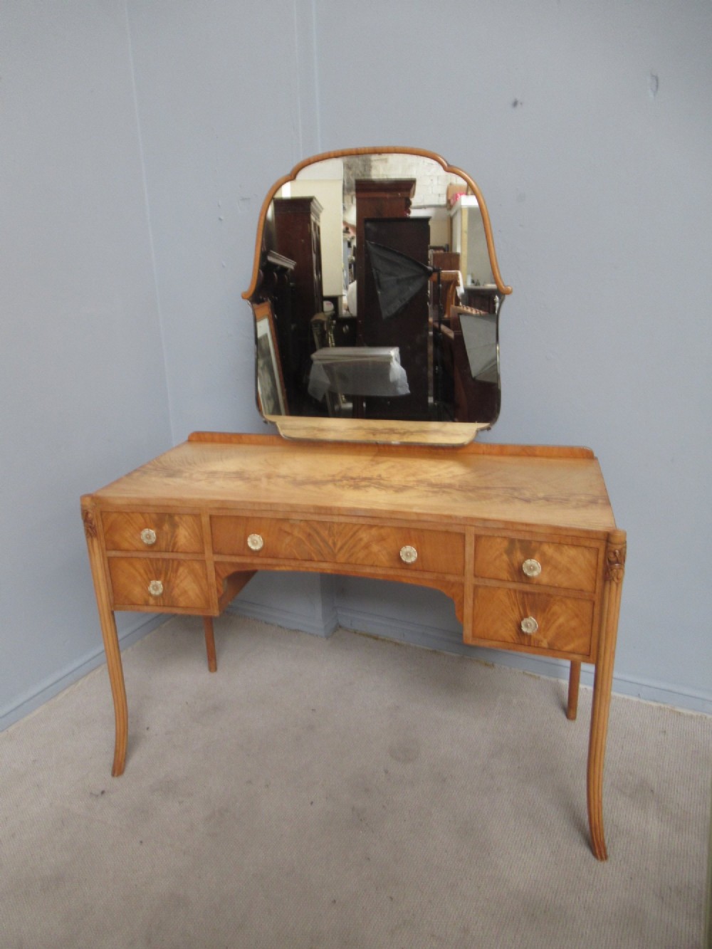A 1930s Art Deco dressing table made from pale mahogany and maple, featuring an attached arched mirror, five drawers, and slender carved legs. View II