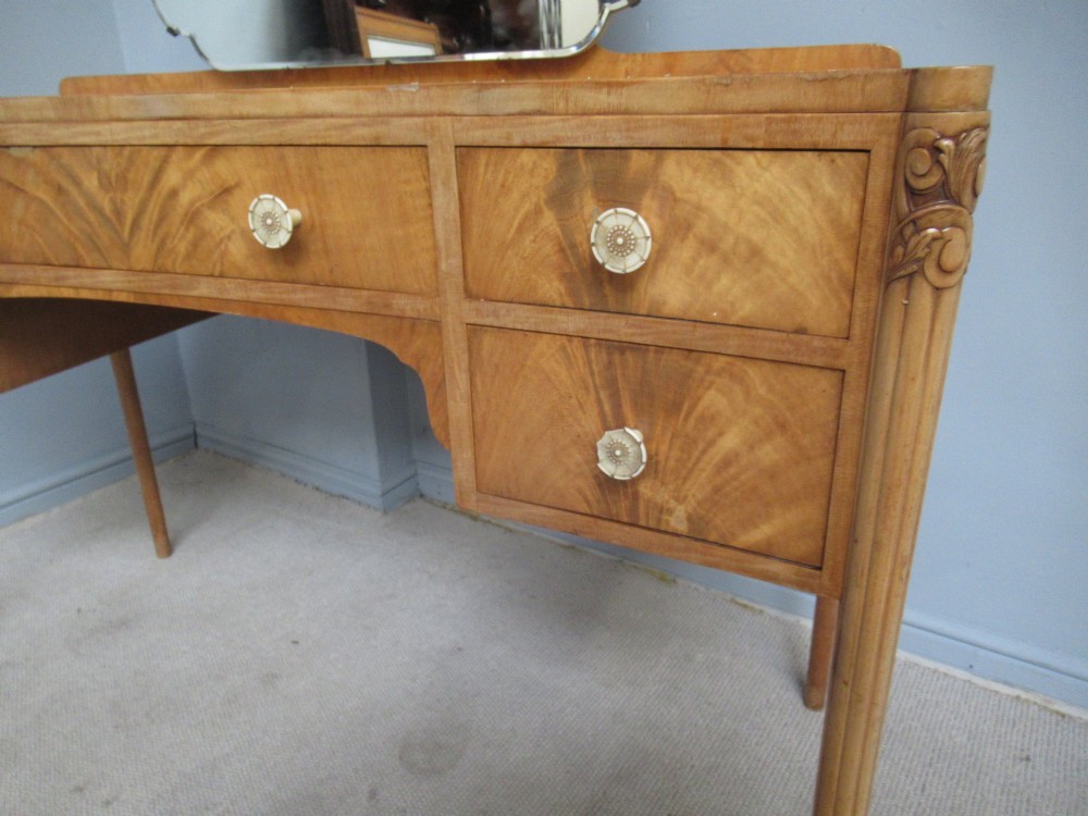 A 1930s Art Deco dressing table made from pale mahogany and maple, featuring an attached arched mirror, five drawers, and slender carved legs. View VI