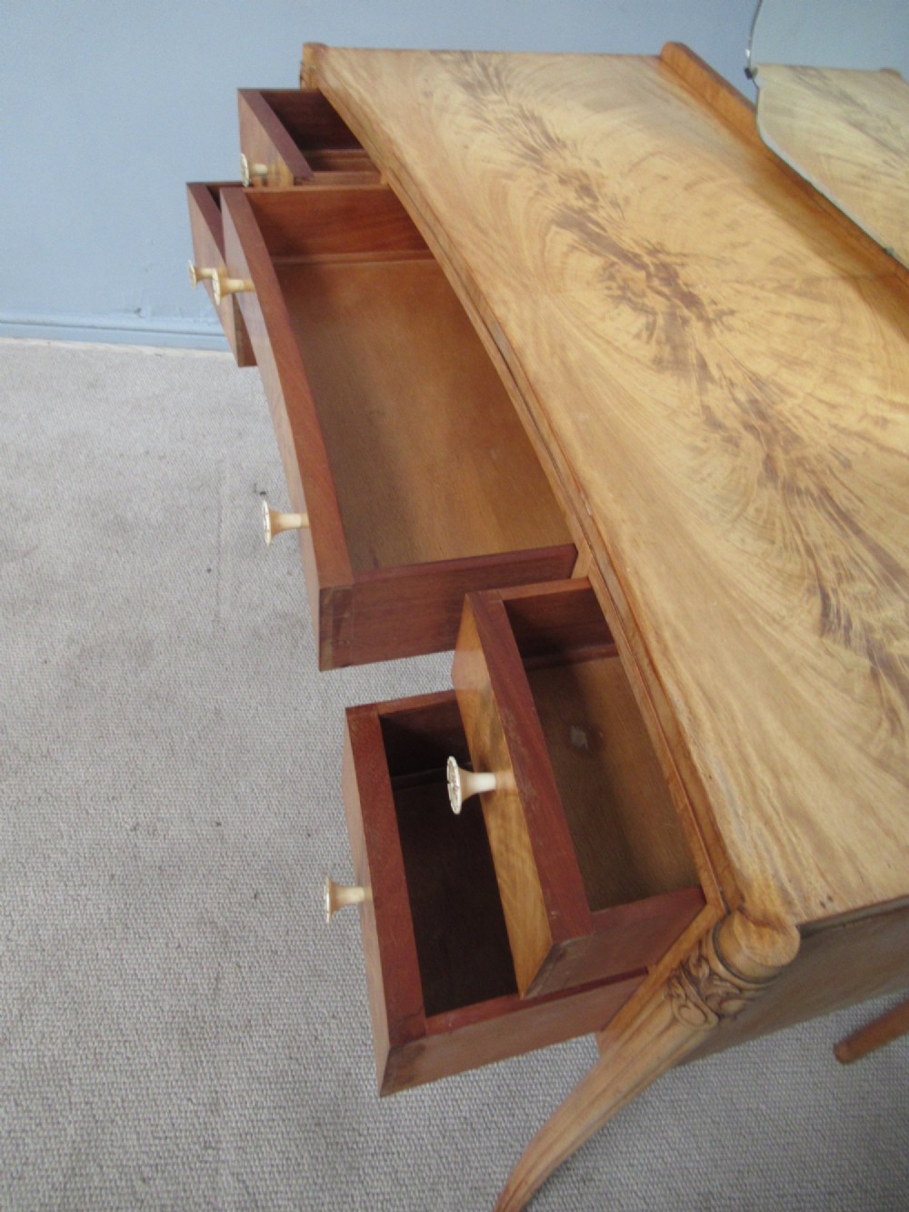A 1930s Art Deco dressing table made from pale mahogany and maple, featuring an attached arched mirror, five drawers, and slender carved legs. View VIII
