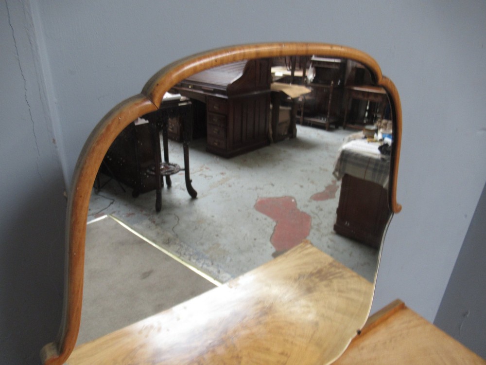 A 1930s Art Deco dressing table made from pale mahogany and maple, featuring an attached arched mirror, five drawers, and slender carved legs. View IX