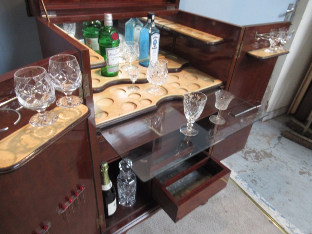 A mahogany Chippendale style cocktail cabinet shown open, revealing a mirrored interior, glass rack holders, and carved cabriole legs with ball-and-claw feet. View III