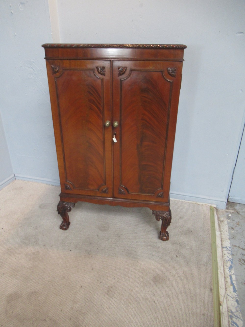 A mahogany Chippendale style cocktail cabinet shown open, revealing a mirrored interior, glass rack holders, and carved cabriole legs with ball-and-claw feet. View V