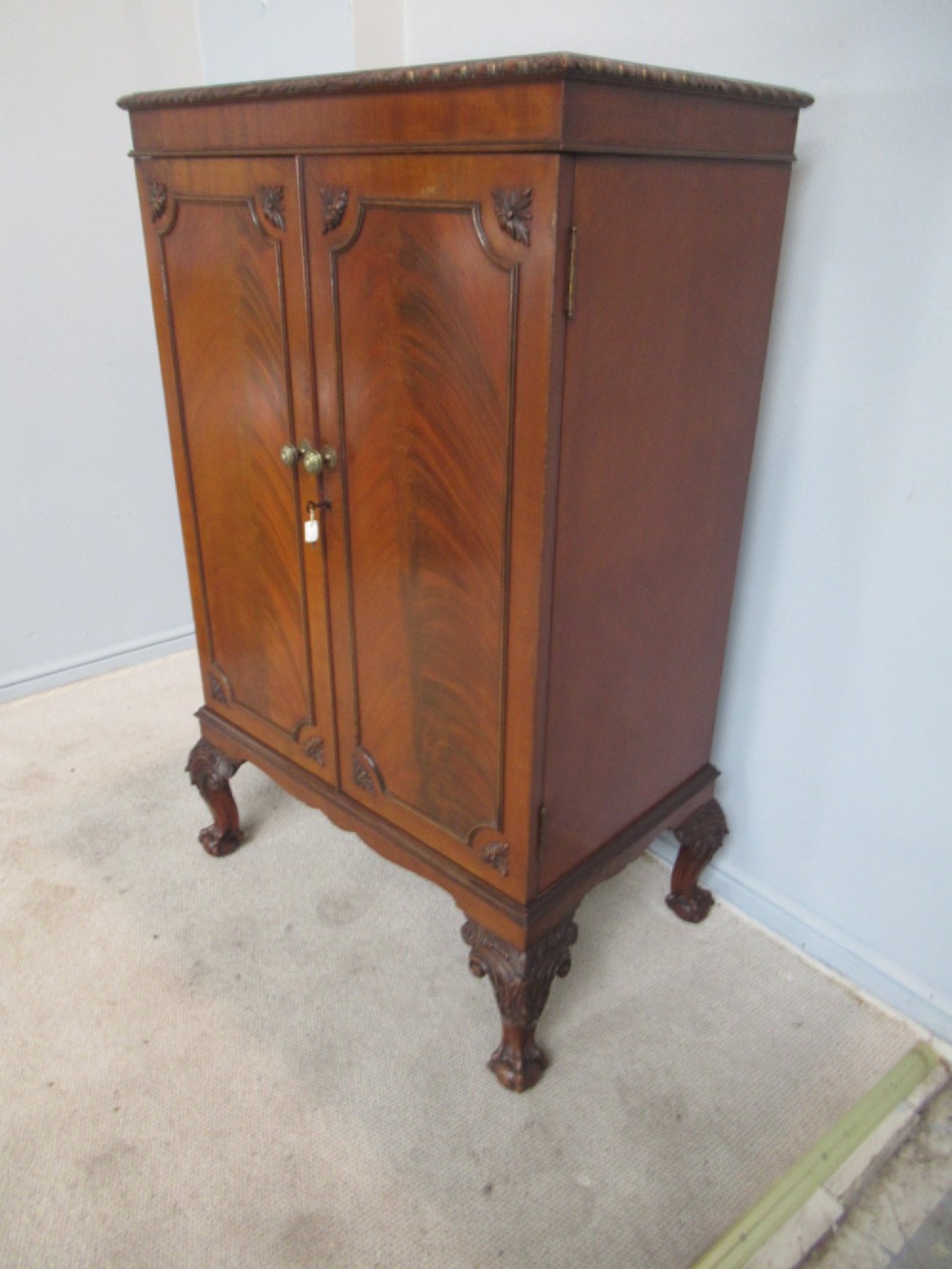 A mahogany Chippendale style cocktail cabinet shown open, revealing a mirrored interior, glass rack holders, and carved cabriole legs with ball-and-claw feet. View VI