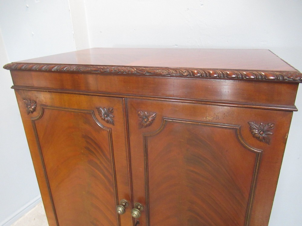 A mahogany Chippendale style cocktail cabinet shown open, revealing a mirrored interior, glass rack holders, and carved cabriole legs with ball-and-claw feet. View VII