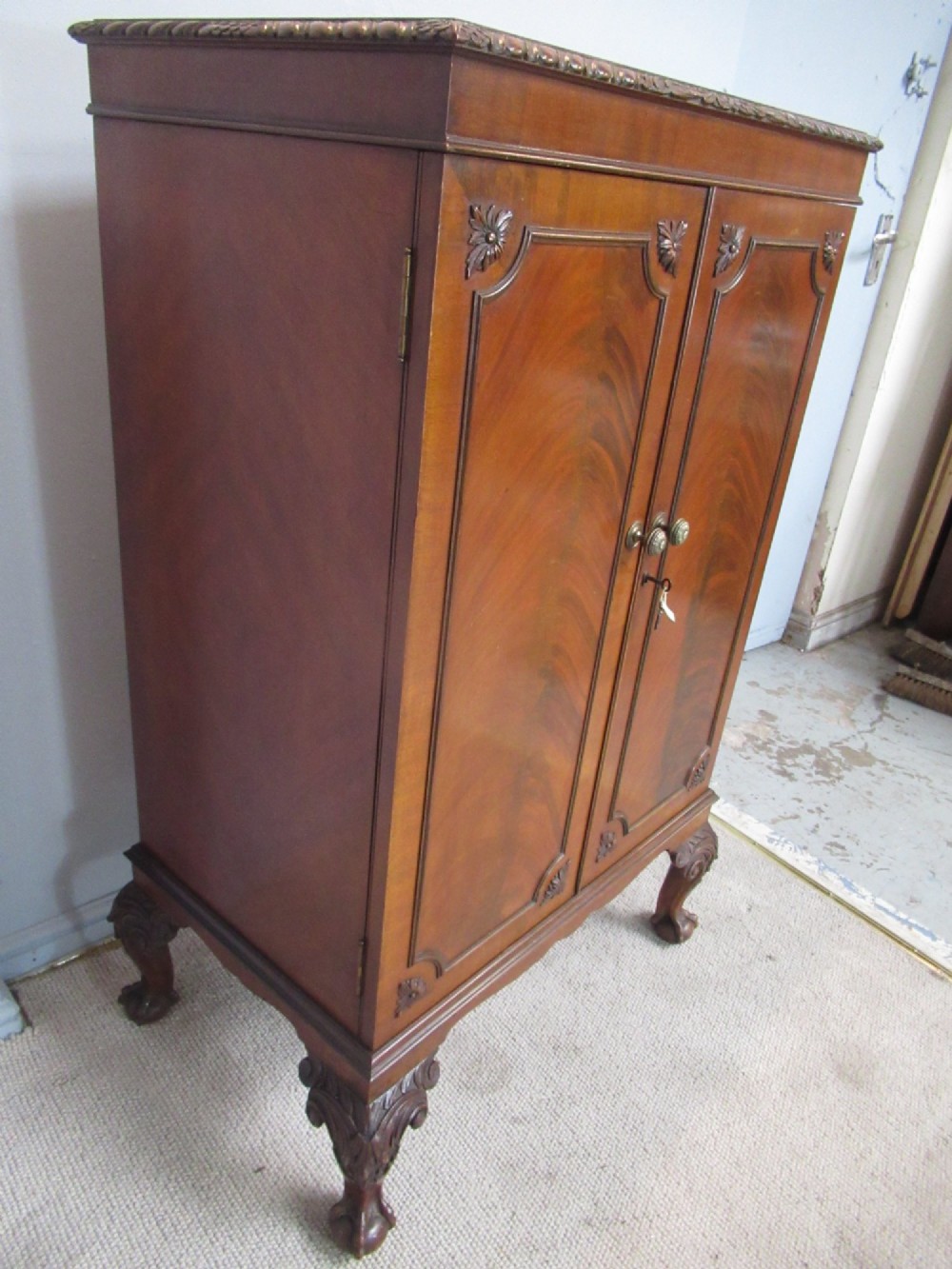 A mahogany Chippendale style cocktail cabinet shown open, revealing a mirrored interior, glass rack holders, and carved cabriole legs with ball-and-claw feet. View XI