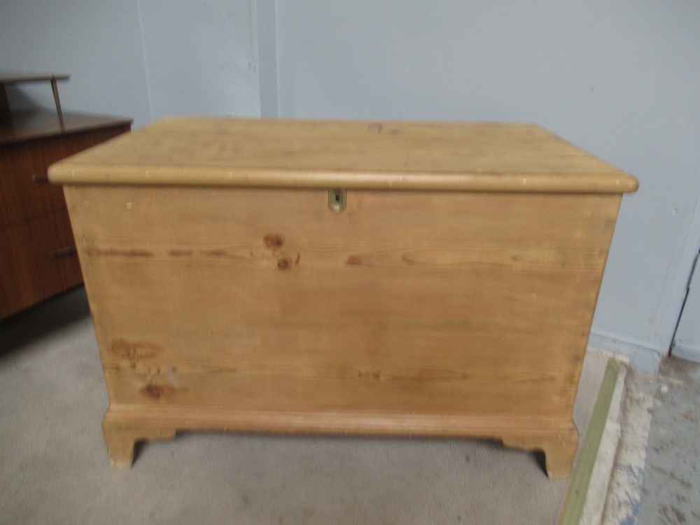 A nineteenth-century pine blanket box featuring a hinged lid, brass escutcheon, and bracket feet. View II