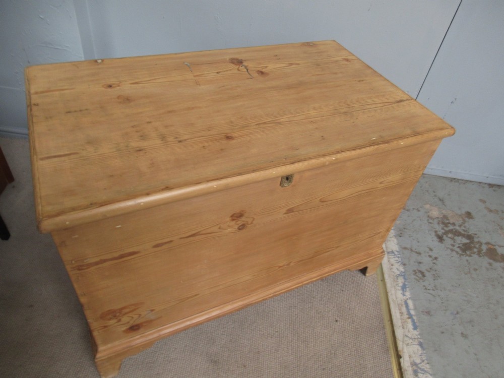 A nineteenth-century pine blanket box featuring a hinged lid, brass escutcheon, and bracket feet. View III