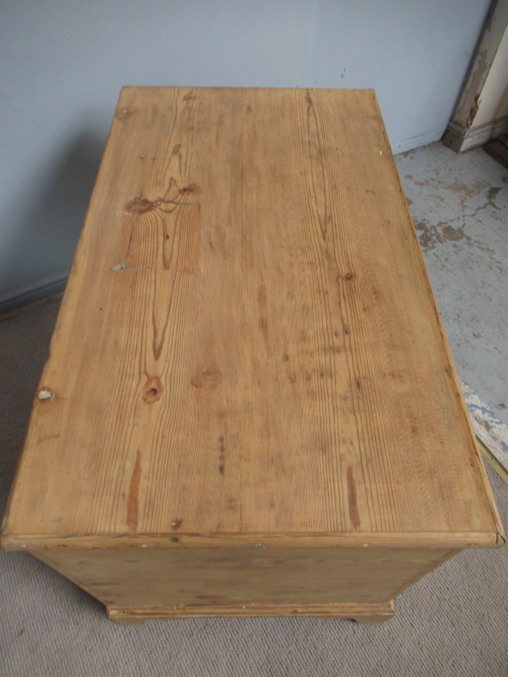 A nineteenth-century pine blanket box featuring a hinged lid, brass escutcheon, and bracket feet. View IV