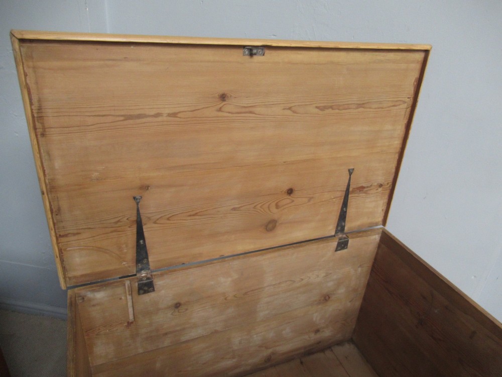 A nineteenth-century pine blanket box featuring a hinged lid, brass escutcheon, and bracket feet. View VI