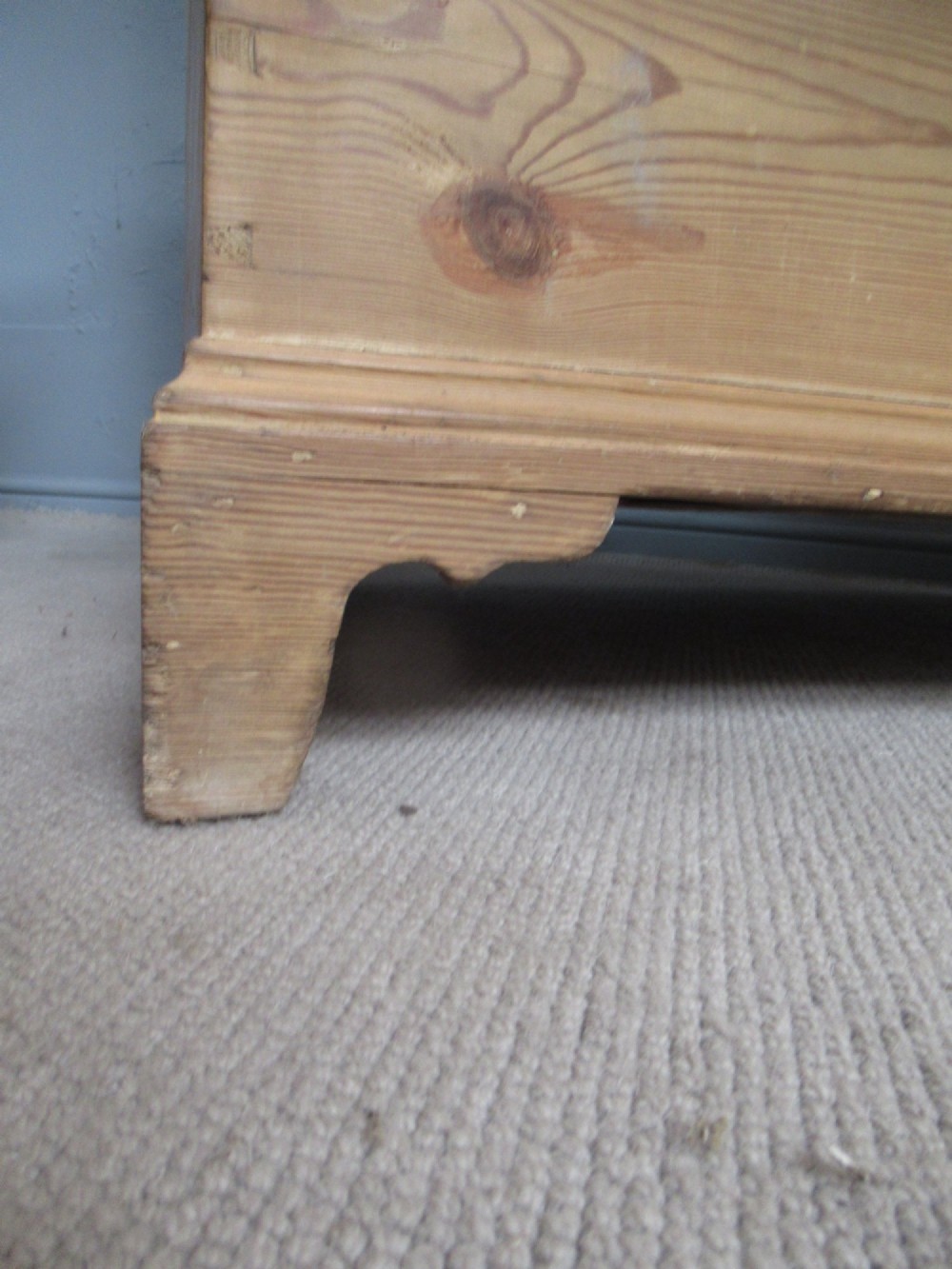 A nineteenth-century pine blanket box featuring a hinged lid, brass escutcheon, and bracket feet. View X