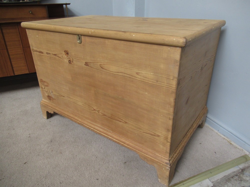 A nineteenth-century pine blanket box featuring a hinged lid, brass escutcheon, and bracket feet. View XI