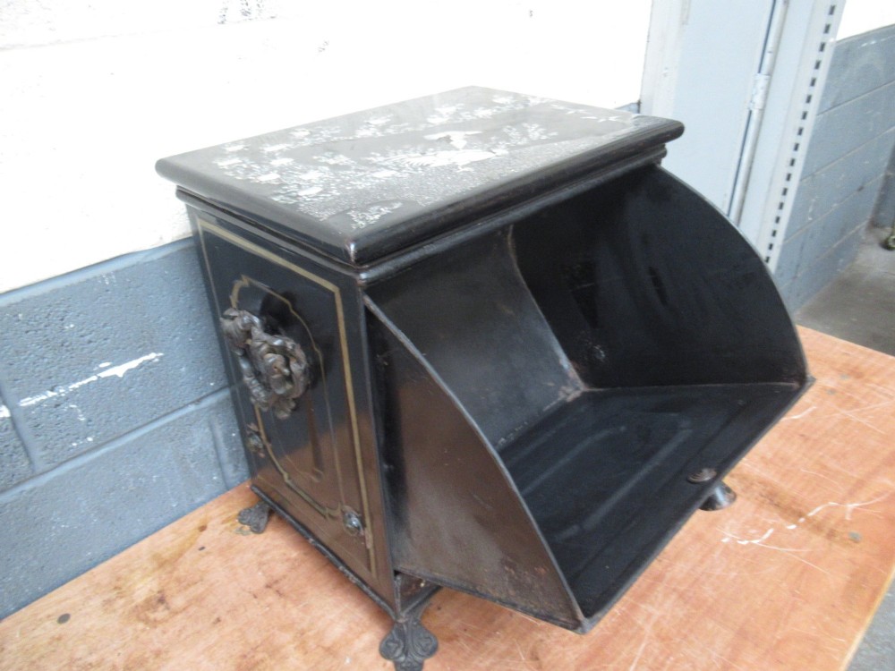 A black metal Victorian coal box featuring mother of pearl inlay depictions of a bird and floral branches, resting on cast metal feet. View IV