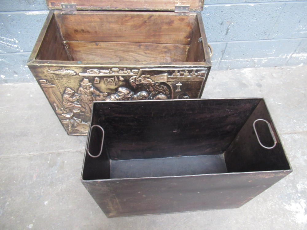 A rectangular Victorian brass log box featuring a detailed embossed relief scene of figures inside a room on the front panel. View XII