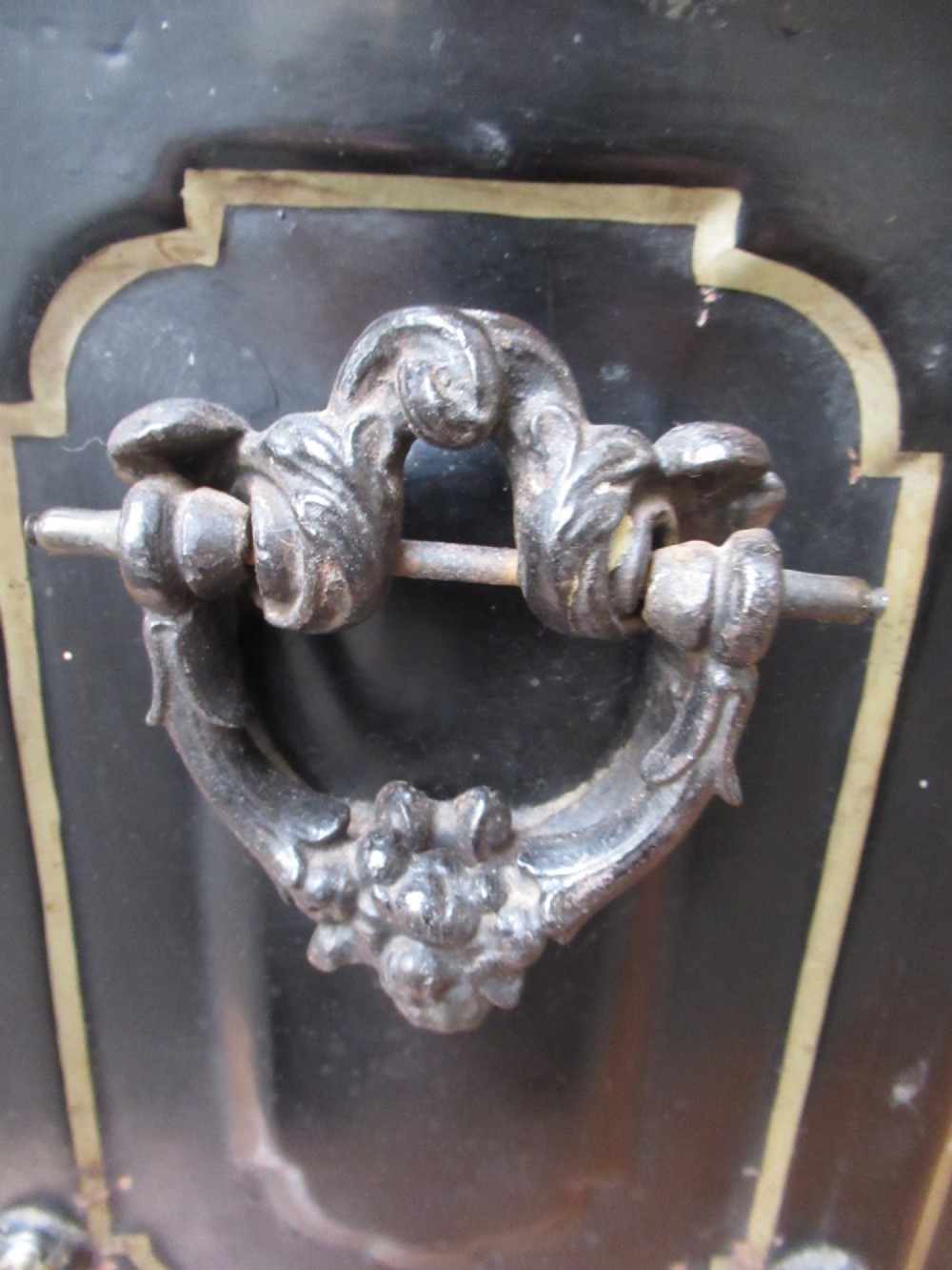 A black metal Victorian coal box featuring mother of pearl inlay depictions of a bird and floral branches, resting on cast metal feet. View VII