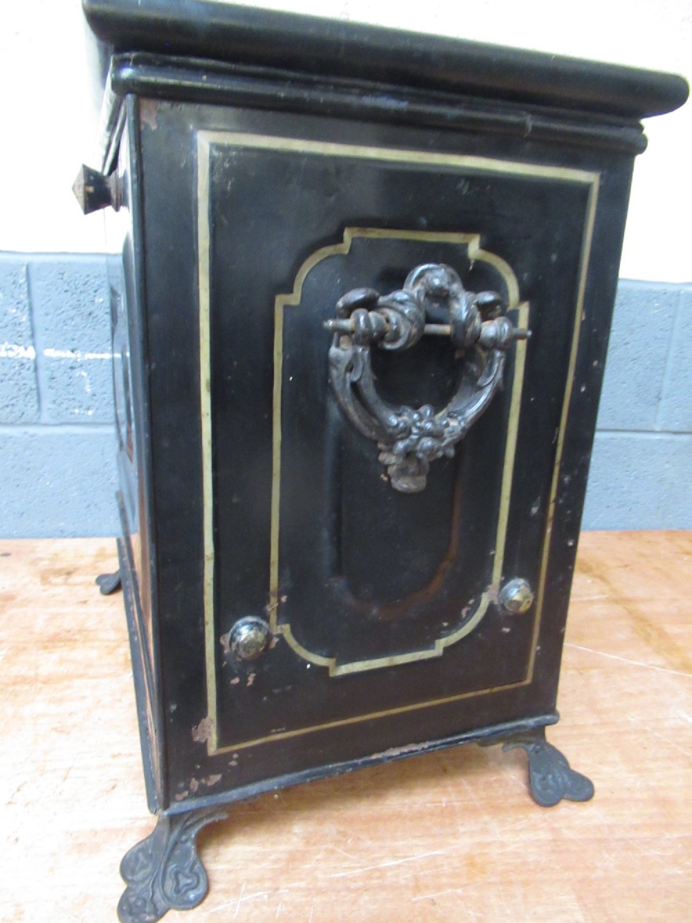 A black metal Victorian coal box featuring mother of pearl inlay depictions of a bird and floral branches, resting on cast metal feet. View VIII