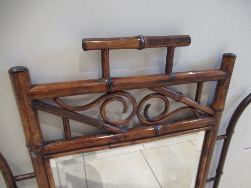 A late Victorian bamboo wall mirror featuring a rectangular bevelled glass plate, bent bamboo scrollwork cresting, side hooks, and a small base drawer with a brass handle. View III