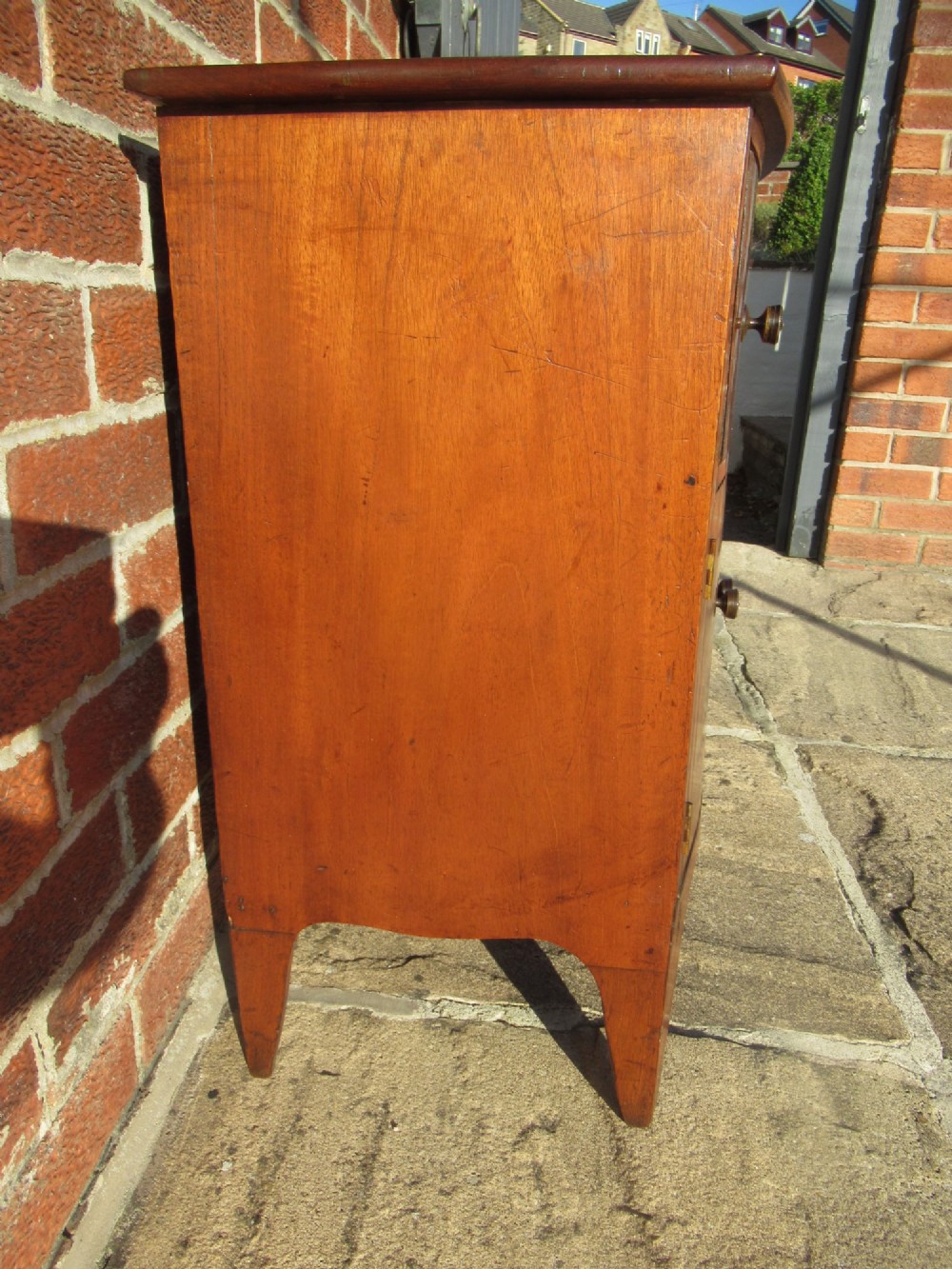 A bowfront Victorian mahogany side cabinet featuring a top drawer and two cupboard doors with flame veneer panels. View III