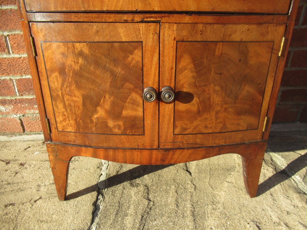 A bowfront Victorian mahogany side cabinet featuring a top drawer and two cupboard doors with flame veneer panels. View VIII