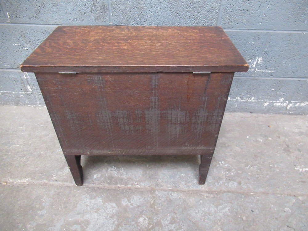 A small dark carved oak coffer featuring two inlaid floral panels, carved arches, and a flat top lid. View VIII