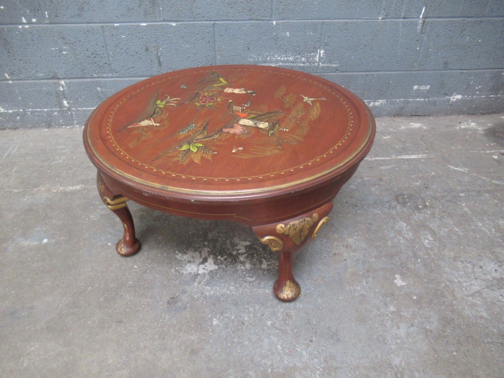 A circular 1930s Chinoiserie coffee table featuring hand-painted oriental figures and flora on a terracotta red lacquered top with gilt-decorated cabriole legs. View VI