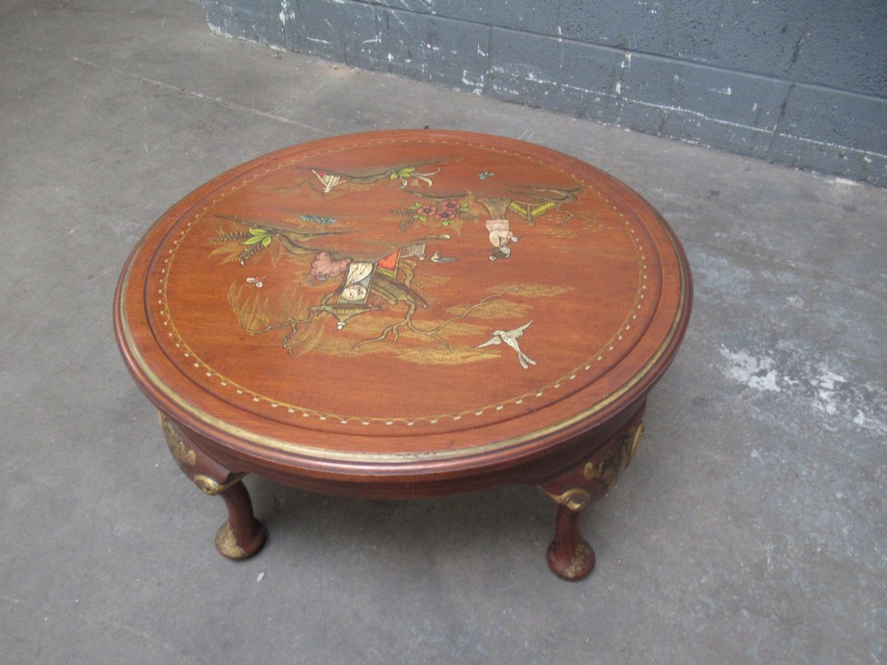A circular 1930s Chinoiserie coffee table featuring hand-painted oriental figures and flora on a terracotta red lacquered top with gilt-decorated cabriole legs. View VIII