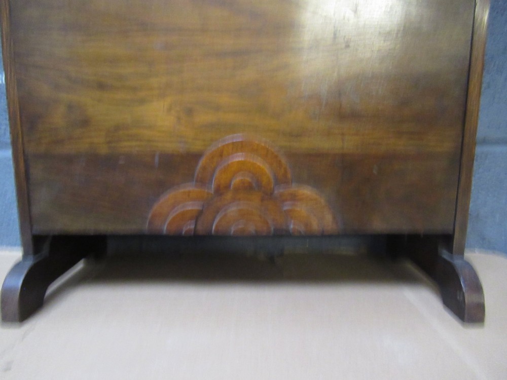 A 1930s dark oak freestanding book rack and magazine holder featuring open shelving above a partitioned lower trough with a carved shell motif. View VI