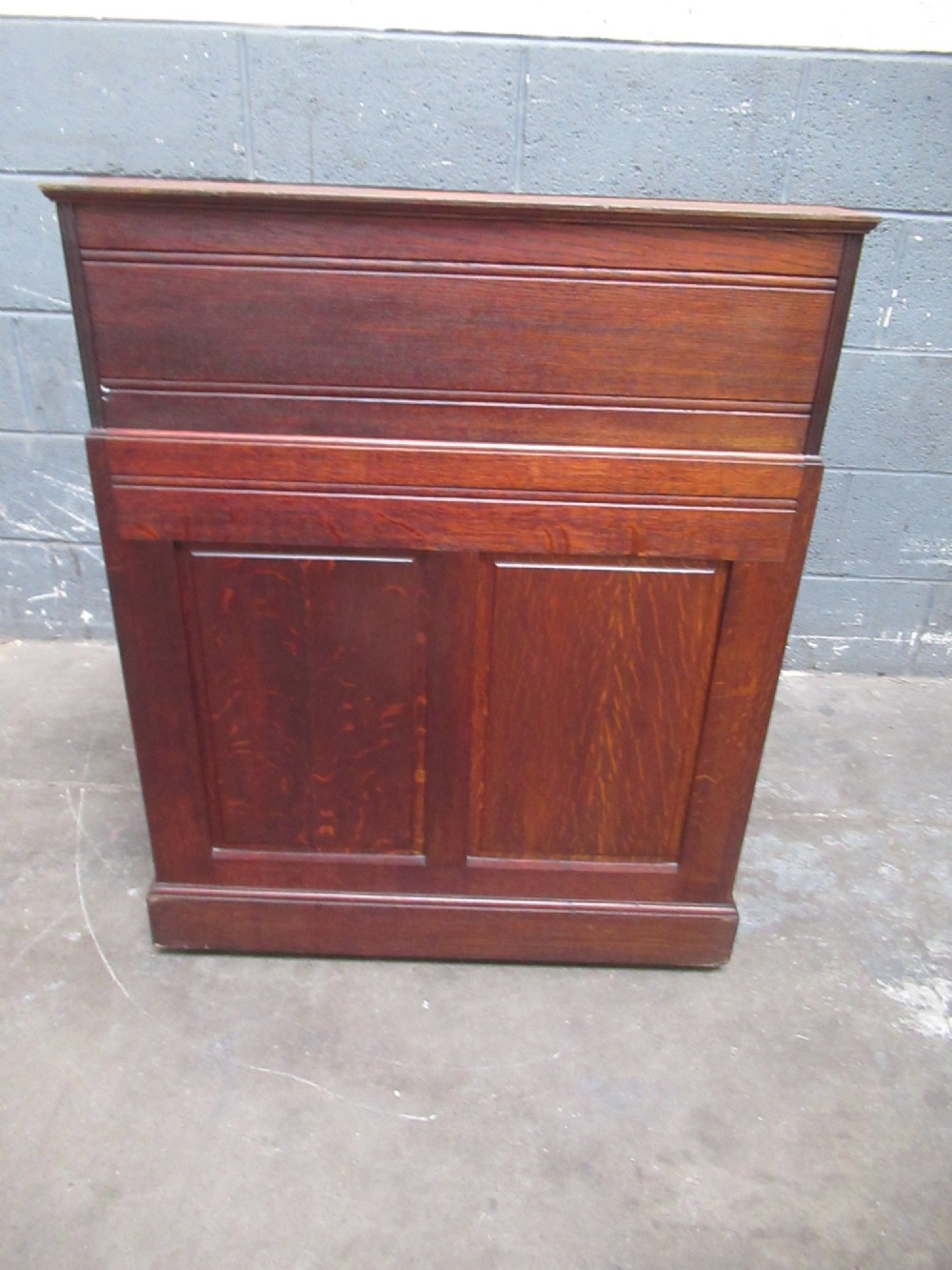 A compact warm brown oak roll top desk featuring a slatted tambour top section, brass ring drawer knobs, a panelled left cupboard, and three stacked side drawers. View XIII