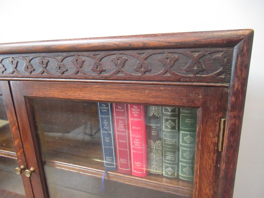 A dark oak two-tiered bookcase featuring six glazed doors, framed glass panels, and a carved top frieze. View VI