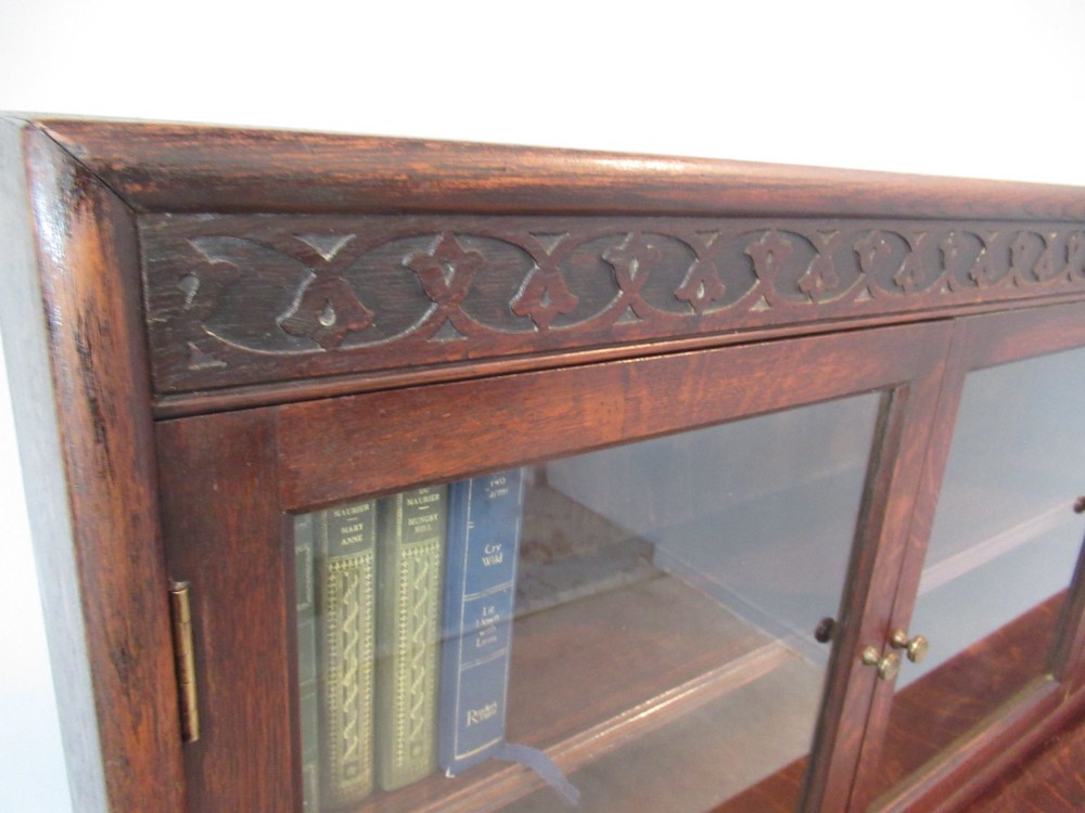 A dark oak two-tiered bookcase featuring six glazed doors, framed glass panels, and a carved top frieze. View VII