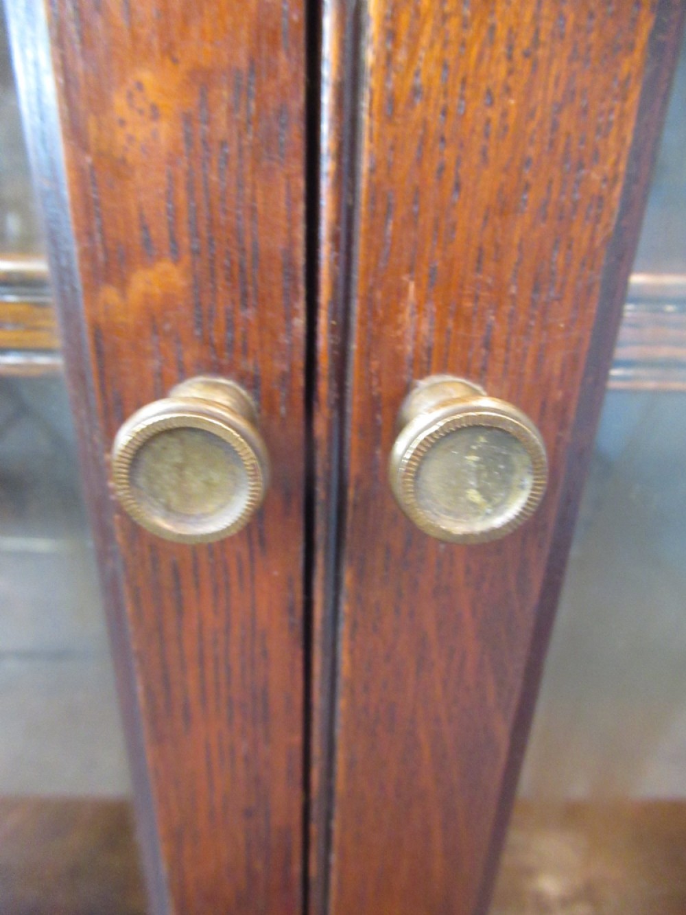 A dark oak two-tiered bookcase featuring six glazed doors, framed glass panels, and a carved top frieze. View VIII