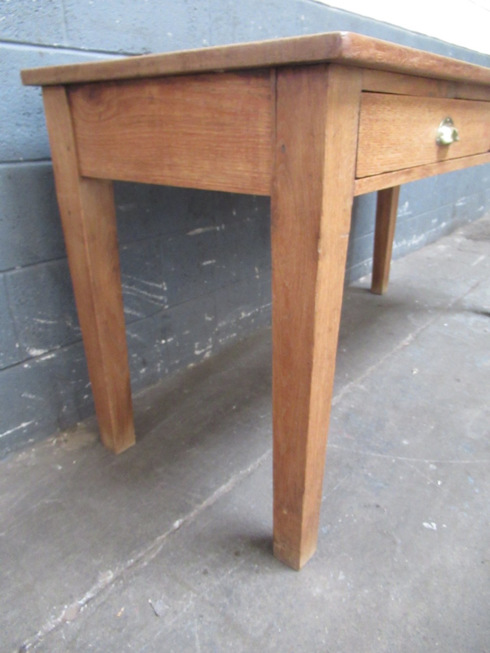 A light oak side table featuring a wide rectangular top, two drawers with brass cup handles, and four straight legs. View II