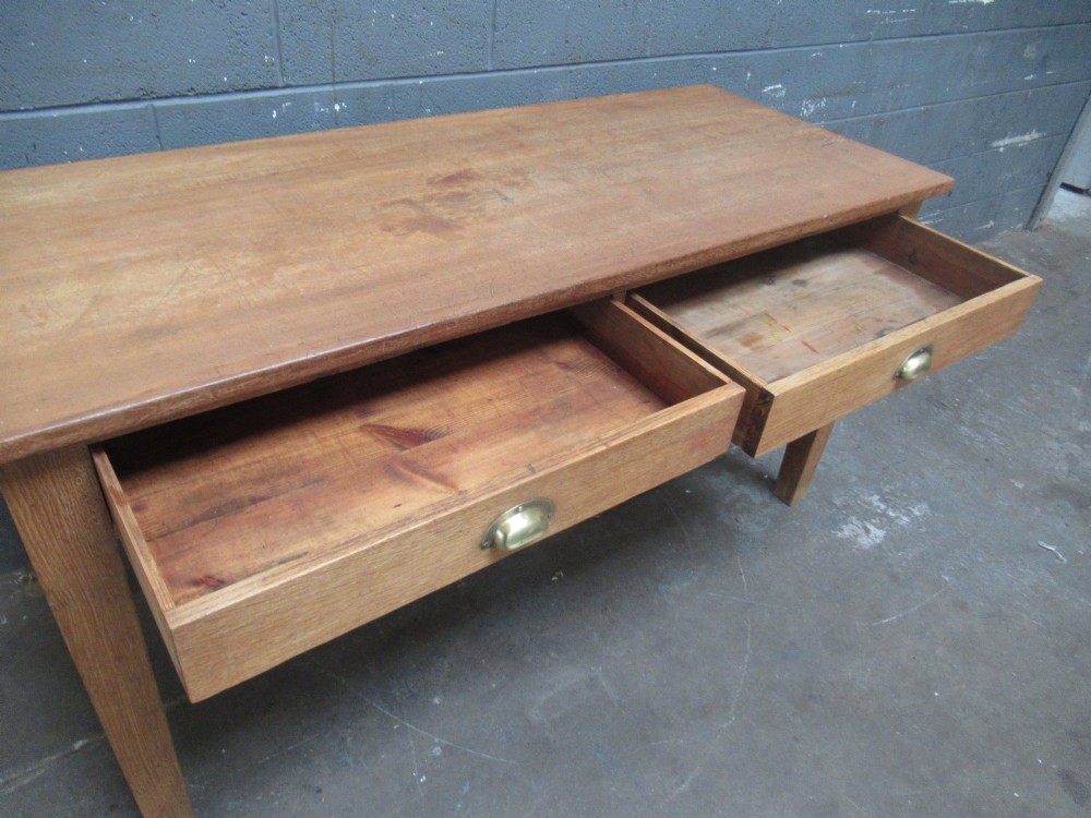 A light oak side table featuring a wide rectangular top, two drawers with brass cup handles, and four straight legs. View VIII