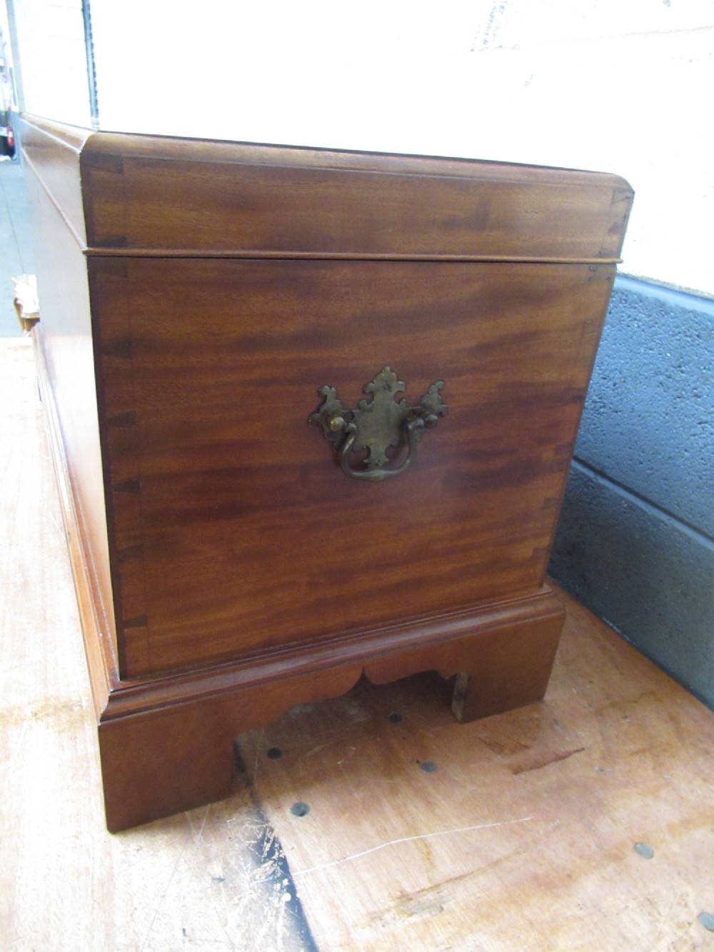 An open mahogany fitted storage chest with internal vertical wood dividers, a keyhole with a dark escutcheon, and a hinged lid. View IV