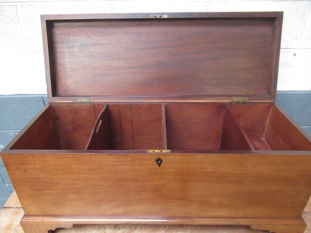 An open mahogany fitted storage chest with internal vertical wood dividers, a keyhole with a dark escutcheon, and a hinged lid. View XI