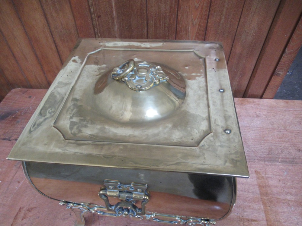 An Edwardian square brass coal box featuring a domed central lid handle, side drop handles, and ornate cast feet. View III