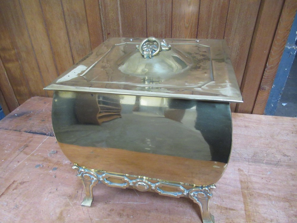 An Edwardian square brass coal box featuring a domed central lid handle, side drop handles, and ornate cast feet. View IV