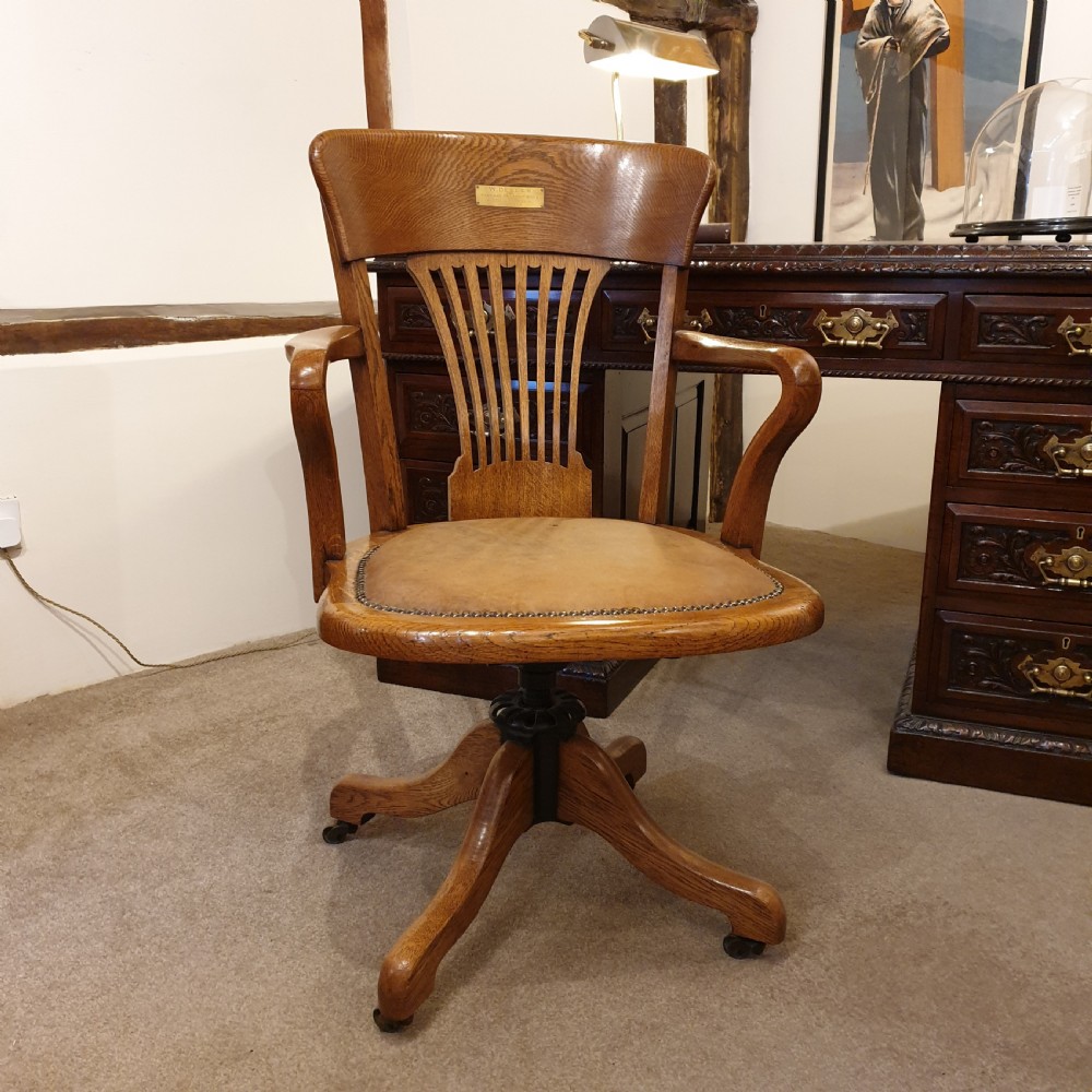 Light oak & leather seated revolving desk chair - presented to W Deedes by the past & present boys in 1912