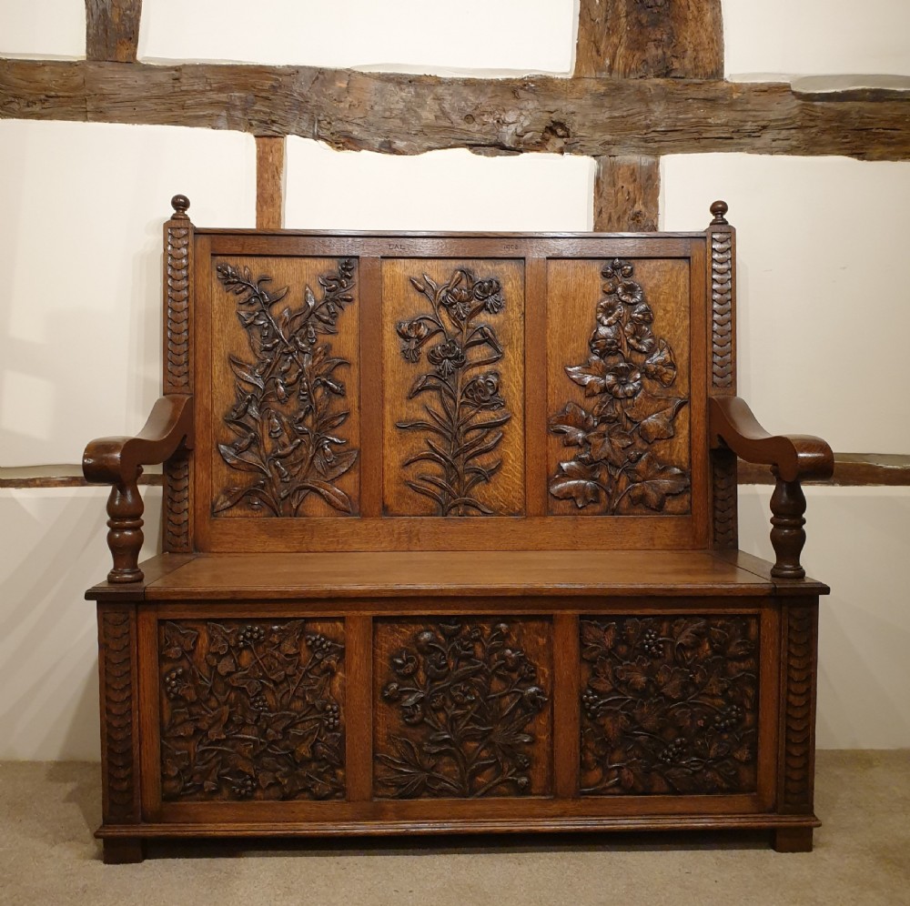 Carved oak box settle - uniquely decorated with garden flowers - initialled & dated 1908