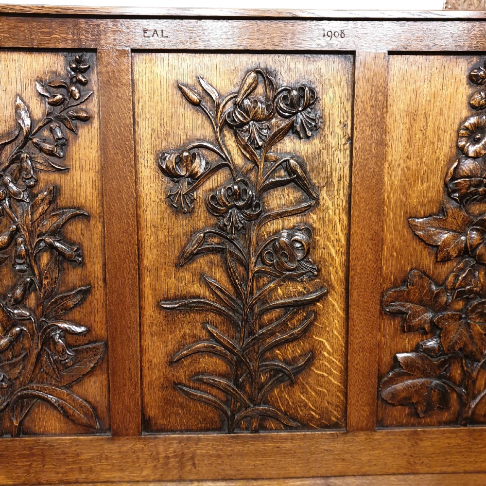 Carved oak box settle - uniquely decorated with garden flowers - initialled & dated 1908 View V