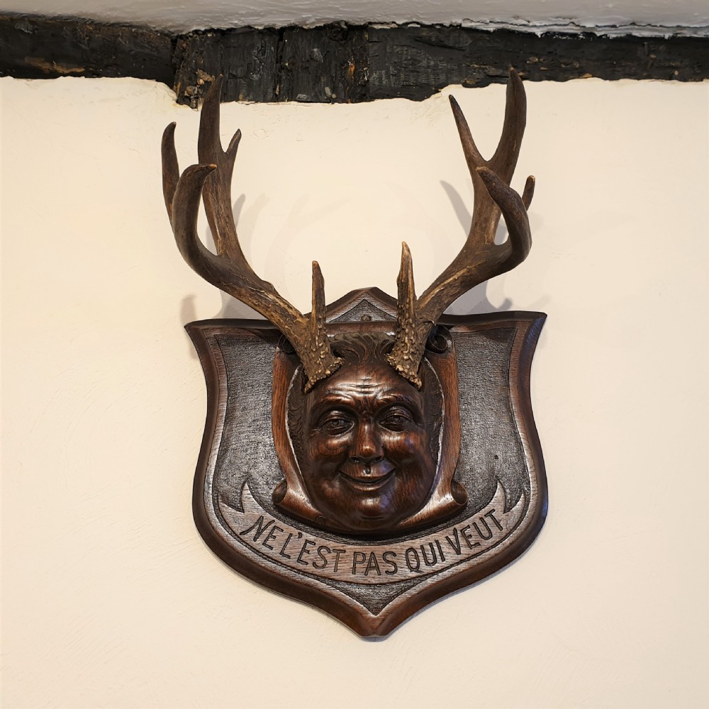A carved oak & stag horned face mask 